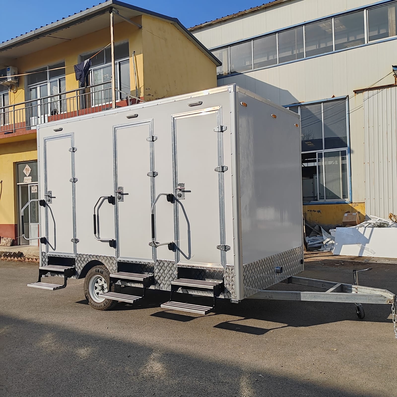 Luxury restroom trailer parked on site, angled view showing entry steps