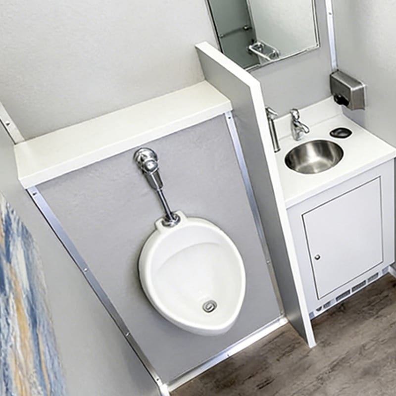 Restroom trailer interior with urinal, stainless sink and mirror